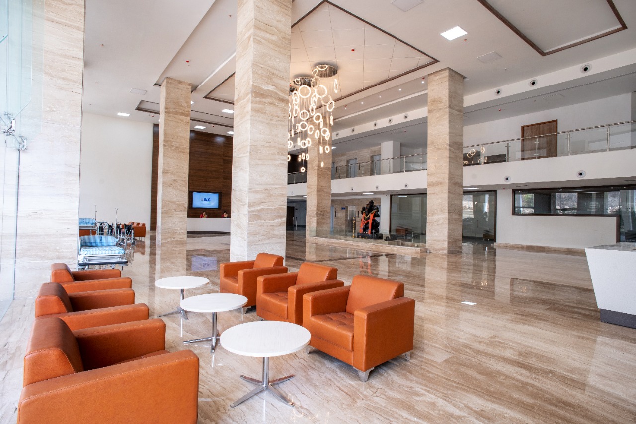 The main atrium at SLG Hospitals: a marble concourse under a first-floor gallery, with lounge seating and the reception desk beyond.